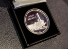 Eine Silbermünze in einer Schatulle. Darauf ist eine Dampflok und die Schrift „Adler Medaille“ geprägt.