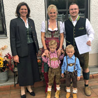 Bauministerin Ilse Aigner übergibt den einen Förderbescheid über 10.000 Euro für die Eigenheimzulage an eine Familie