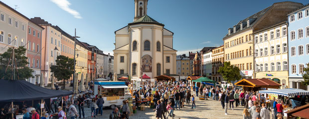 Traunsteiner Apfelmarkt auf dem Traunsteiner Stadtplatz. Viele Fußgängerinnen und Fußgänger halten sich zwischen den Ständen auf.